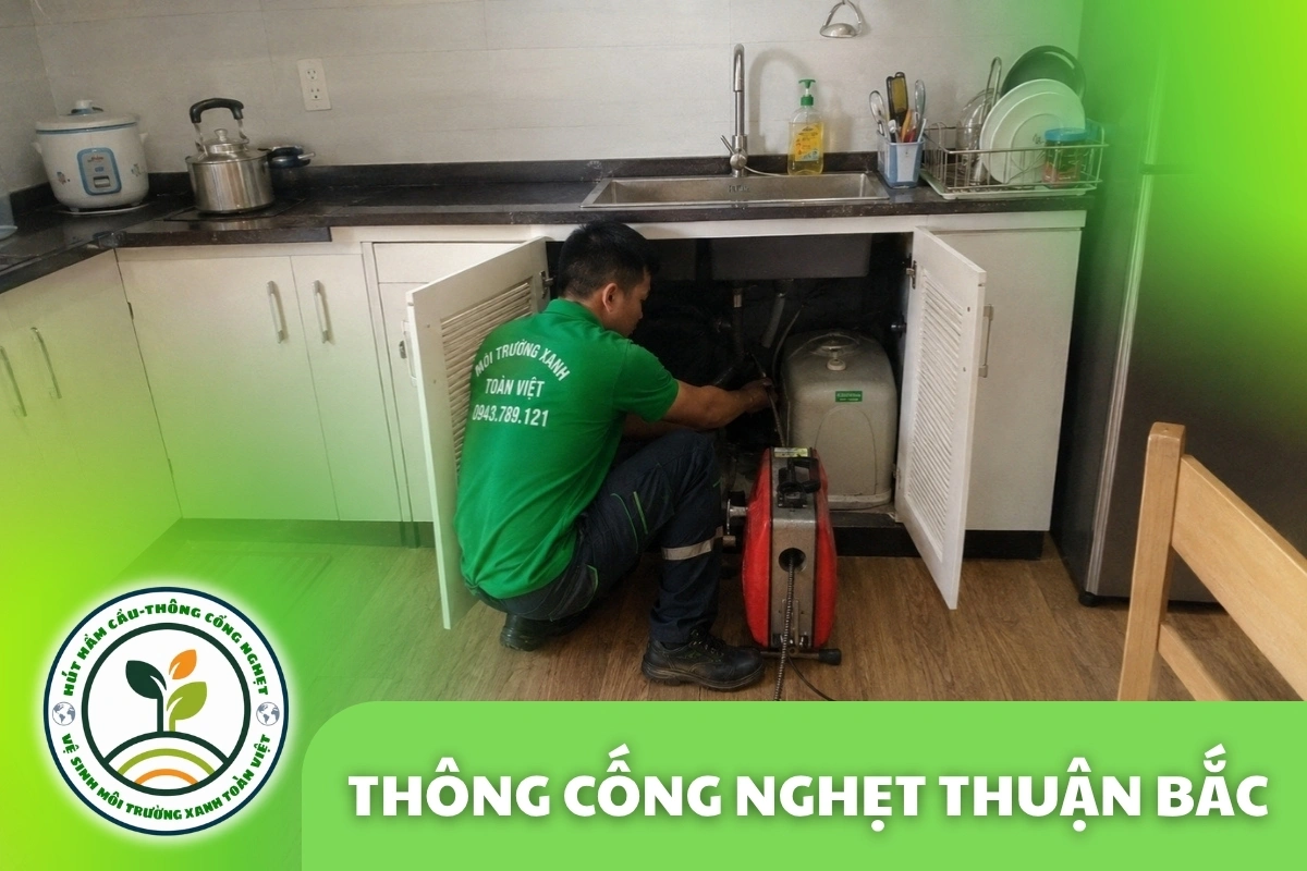 Nhân viên thao tác dưới tủ chậu rửa mở cạnh máy lò xo màu đỏ