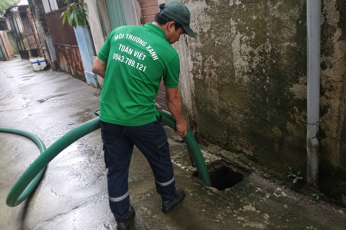 Hút Hầm Cầu Thạnh Hóa Long An 24/7, Xe Tới Tận Nơi 10 Nhân viên môi trường đang đưa ống hút vào trong nhà