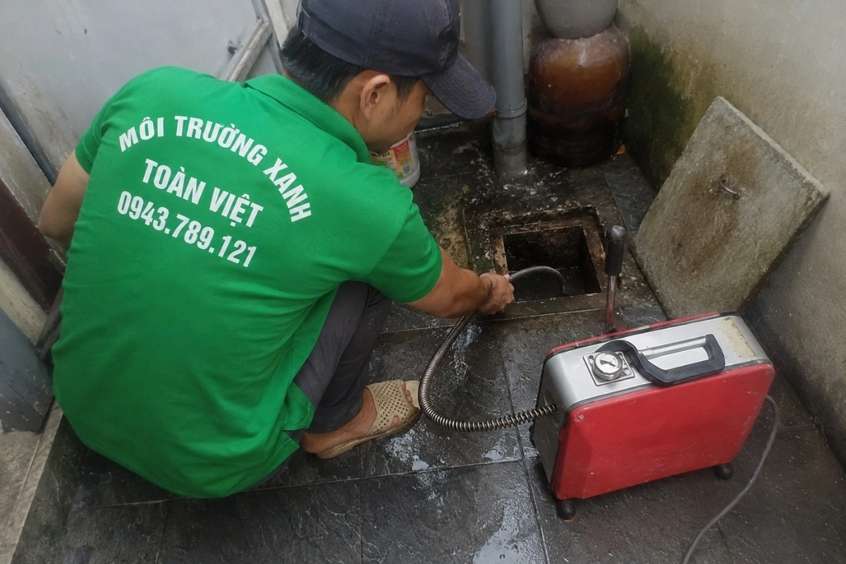 Nhân viên đang làm việc với hệ thống đường ống thoát nước.