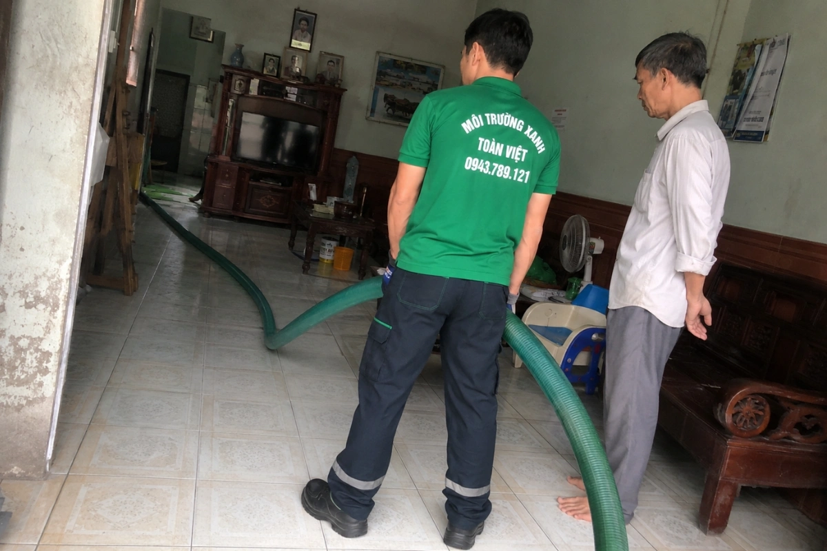 Nhân viên kéo ống hút chuyên dụng qua phòng khách