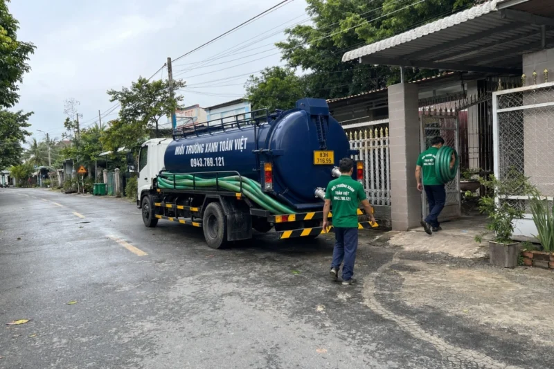 Xe hút hầm cầu màu xanh cùng đội ngũ kỹ thuật