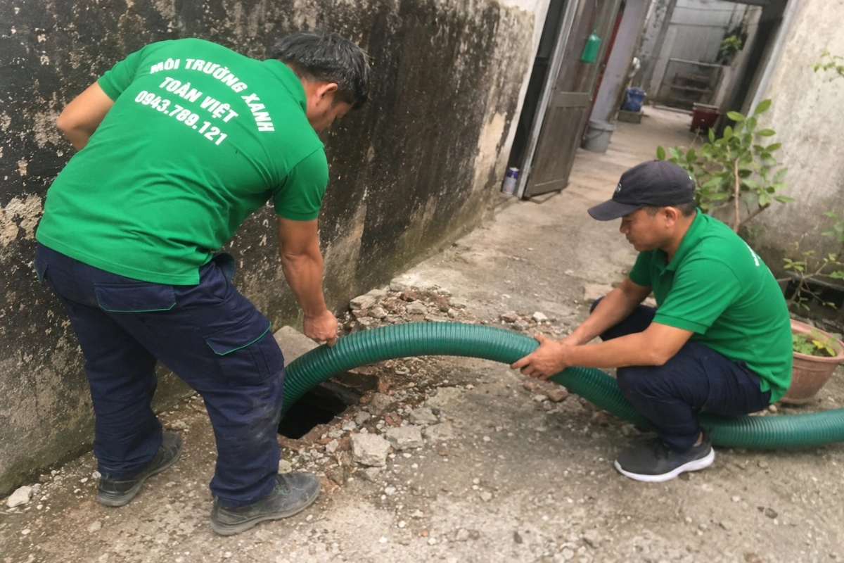 Nhân viên dịch vụ vệ sinh kéo ống hút vào nhà