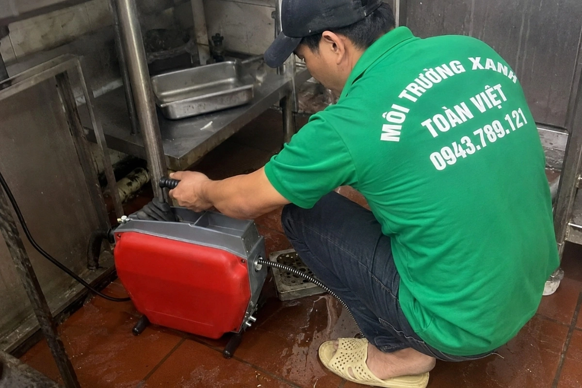 Đội kỹ thuật đang thông cống bằng thiết bị chuyên nghiệp.