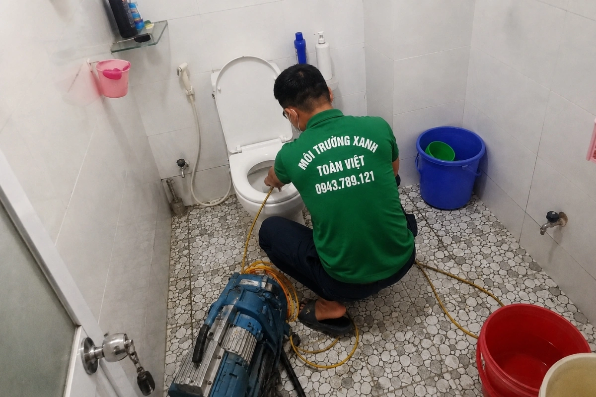 Nhân viên đang kiểm tra vật cản trong hệ thống bồn cầu.