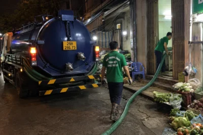 Nhân viên dịch vụ hút hầm cầu đi vào nhà khách hàng