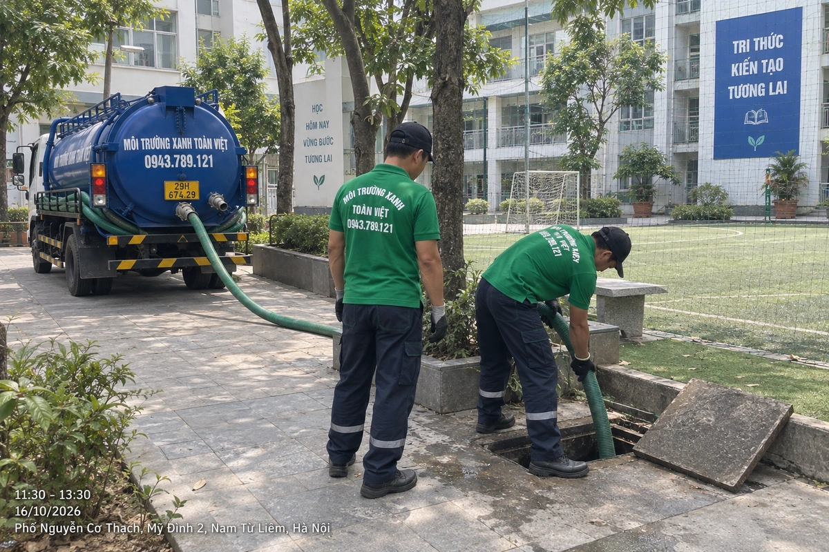 Nhân viên Toàn Việt đặt ống hút tại cửa bể cạnh sân bóng