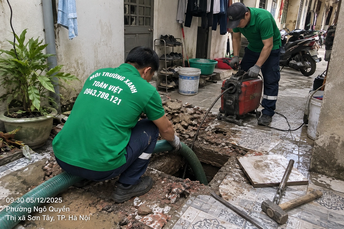 Tiếp cận bể dưới nền khu trọ tại Ngô Quyền, Sơn Tây Nhân viên dùng ống hút và máy lò xo cạnh ô nền đã mở tại khu trọ Ngô Quyền, Sơn Tây