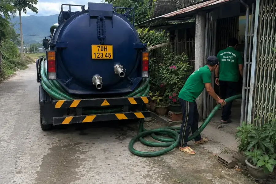 Xe bồn và ống hút trước cổng nhà