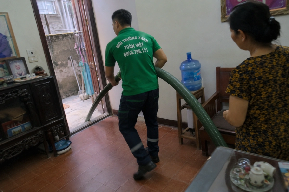 Thợ kéo ống hút hầm cầu dưới sự hướng dẫn của chủ nhà