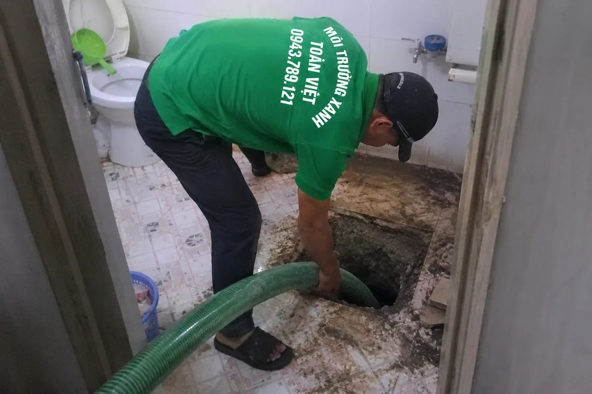 Nhân viên hút hầm cầu trong nhà vệ sinh của gia đình
