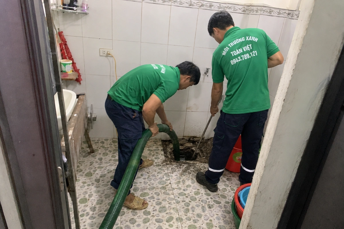 Hút Hầm Cầu Hà Tĩnh Khảo Sát Lối Ống Rồi Mới Báo Giá 14 Hai nhân viên hút hầm cầu tại nắp hầm trong nhà vệ sinh
