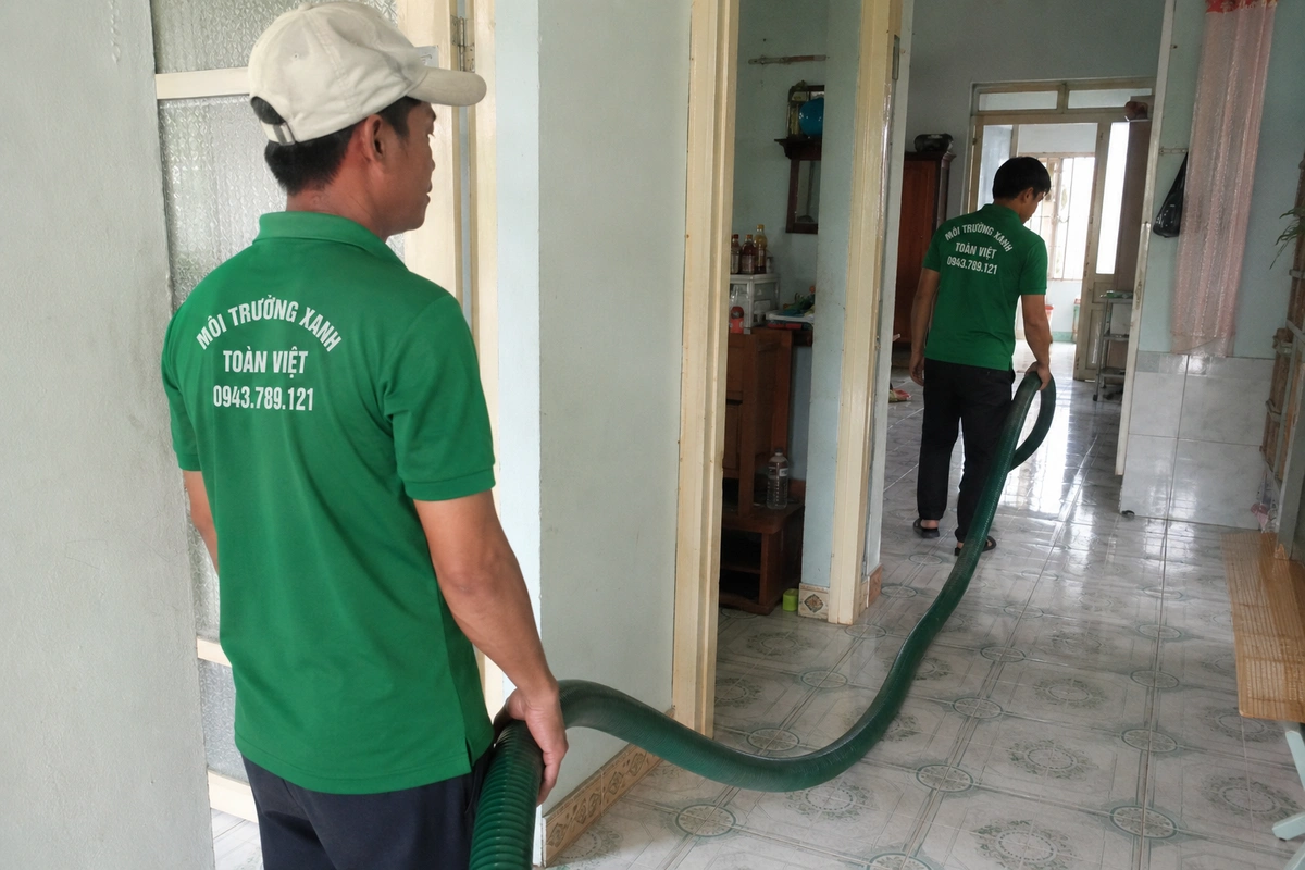 Nhân viên kéo ống hút vào trong nhà để tới miệng hầm