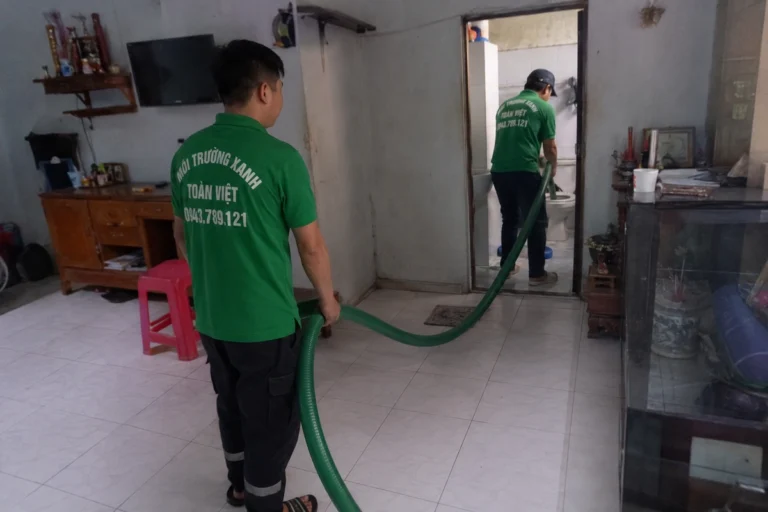 Nhân viên kéo ống hút vào trong nhà để tới miệng hầm