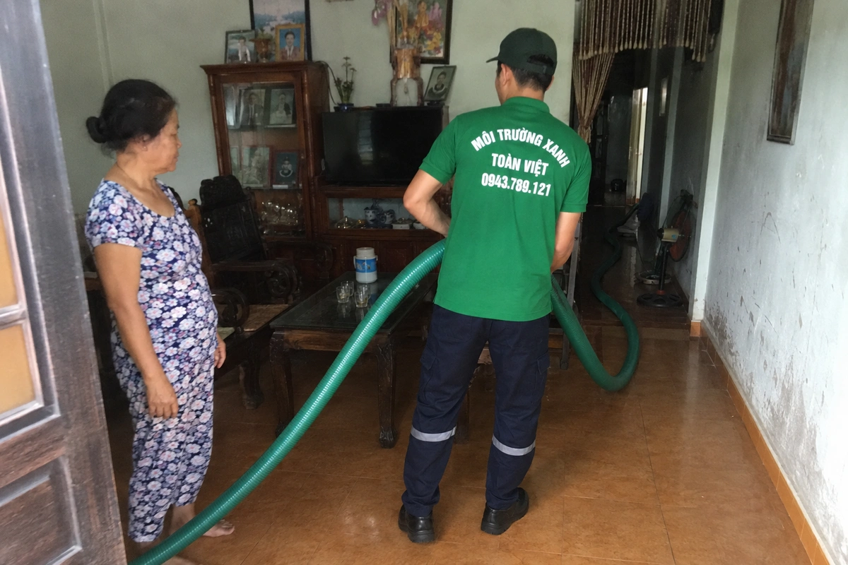 Hút hầm cầu Hoài Ân 24/7 | Môi Trường Xanh Toàn Việt 9 Nhân viên kéo ống hút vào trong nhà để tới miệng hầm