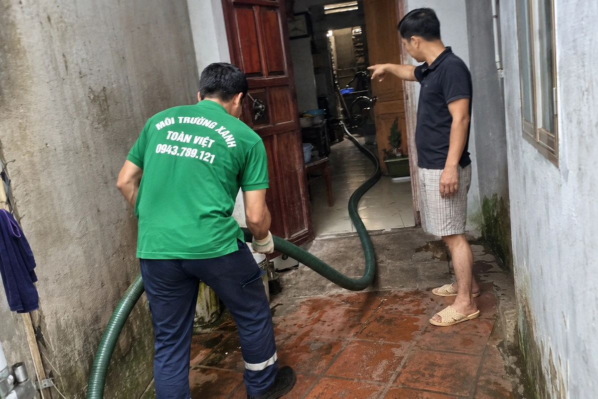 Nhân viên đưa ống hút qua phòng khách tới khu vệ sinh