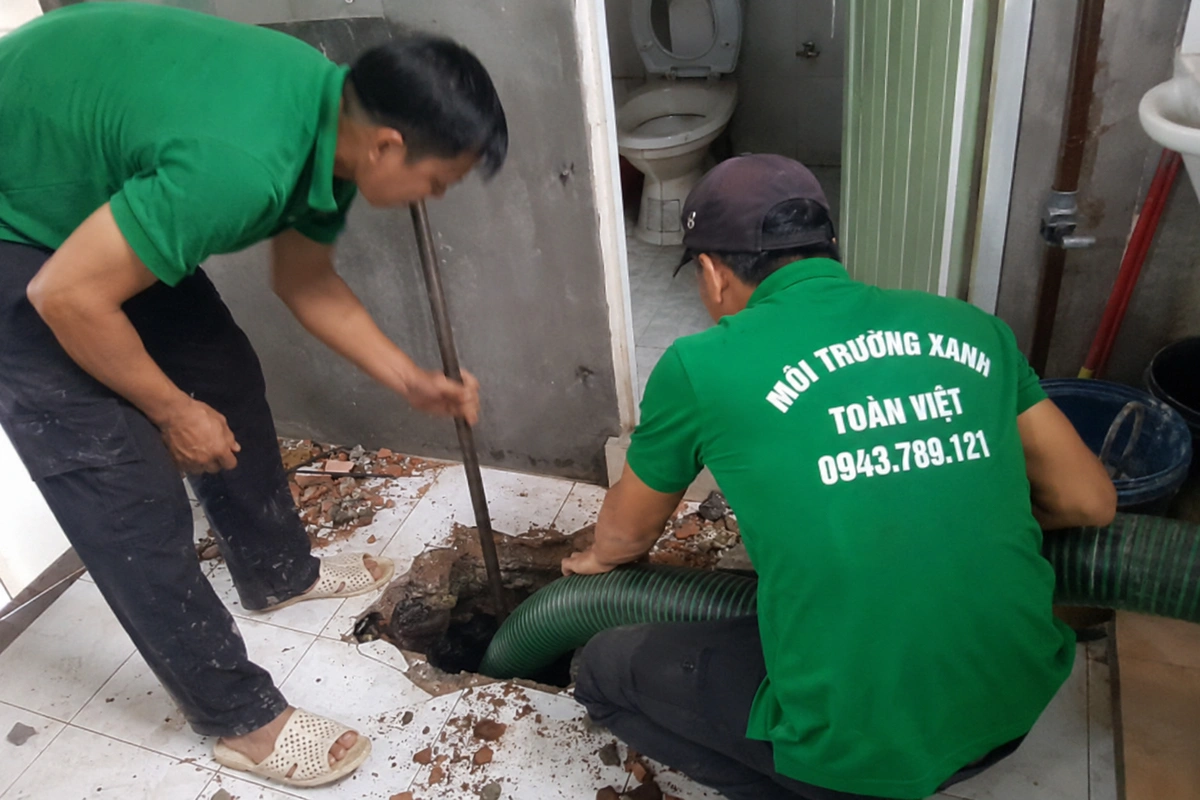 Hút Hầm Cầu Điện Bàn 24/7, Báo Giá Theo Khối | Đến Trong 30 Phút 10 Nhân viên mở miệng hầm cầu trong nhà để đưa ống hút xuống