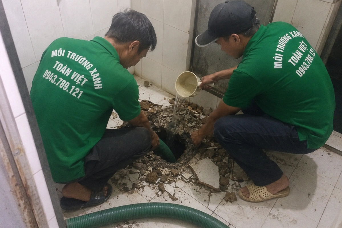 Nhân viên mở miệng hầm cầu trong nhà để đưa ống hút xuống