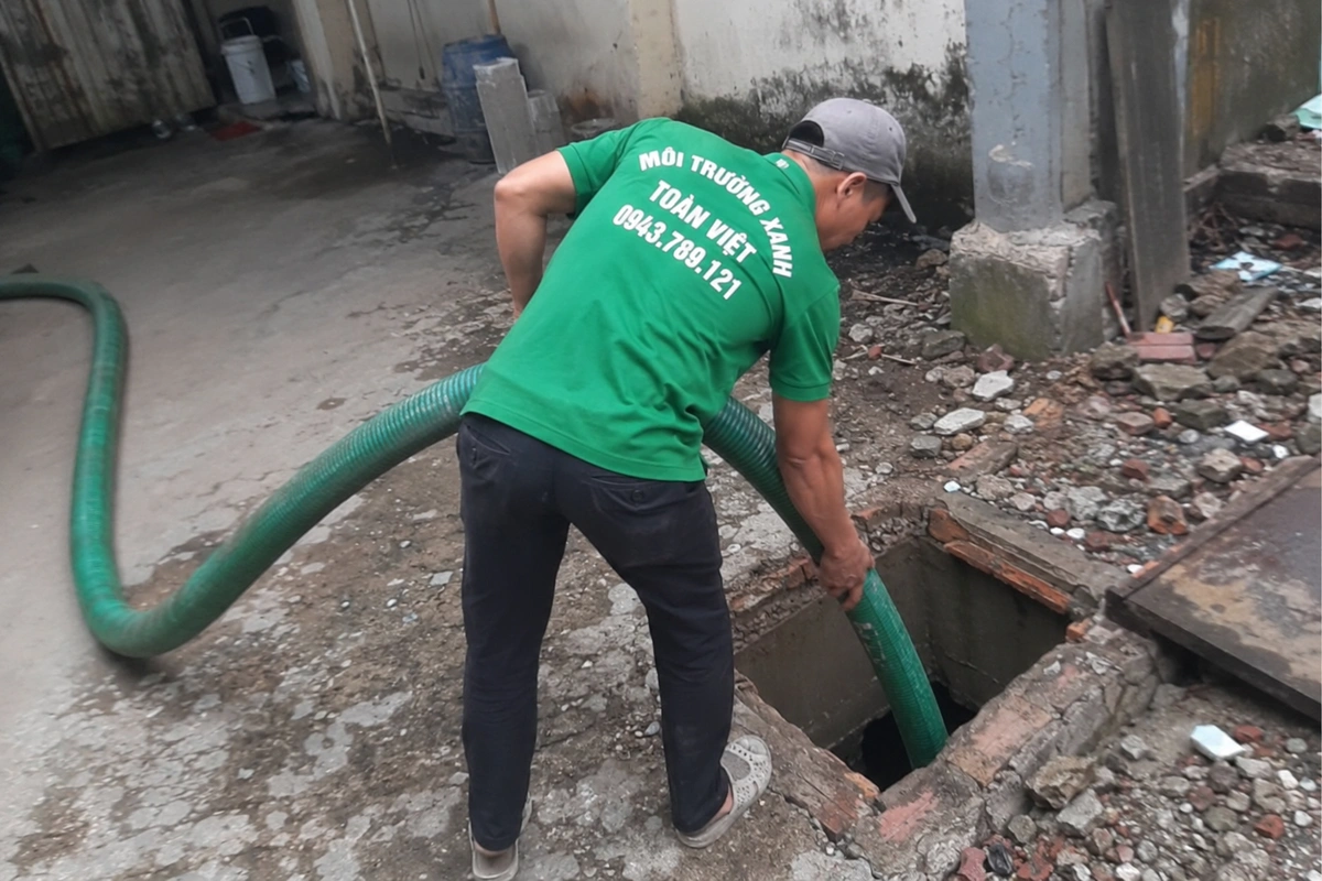 Nhân viên nạo vét cặn trong hầm cầu sau khi hút