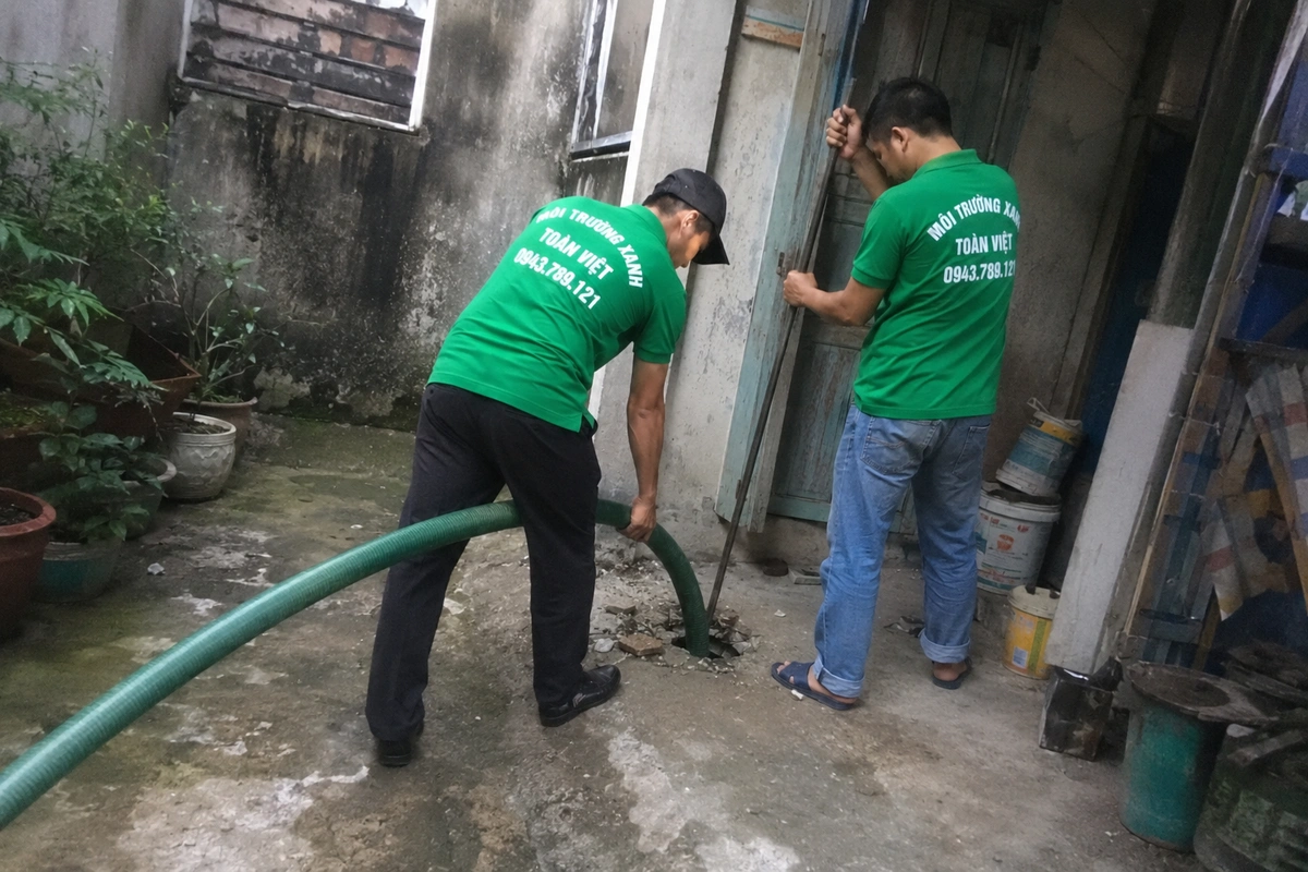 Hút Hầm Cầu Nam Đông 24/7, Cân theo m³ | Xanh Toàn Việt 10 Nhân viên thao tác tại miệng hầm cầu đã mở nắp
