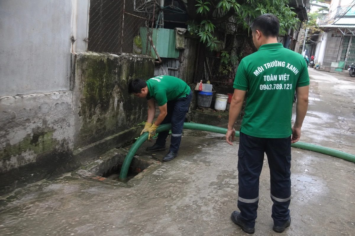 Nhân viên kiểm tra miệng hầm cầu trong lúc hút