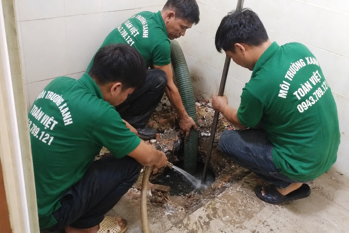 Nhân viên kiểm tra miệng hầm cầu trong lúc hút
