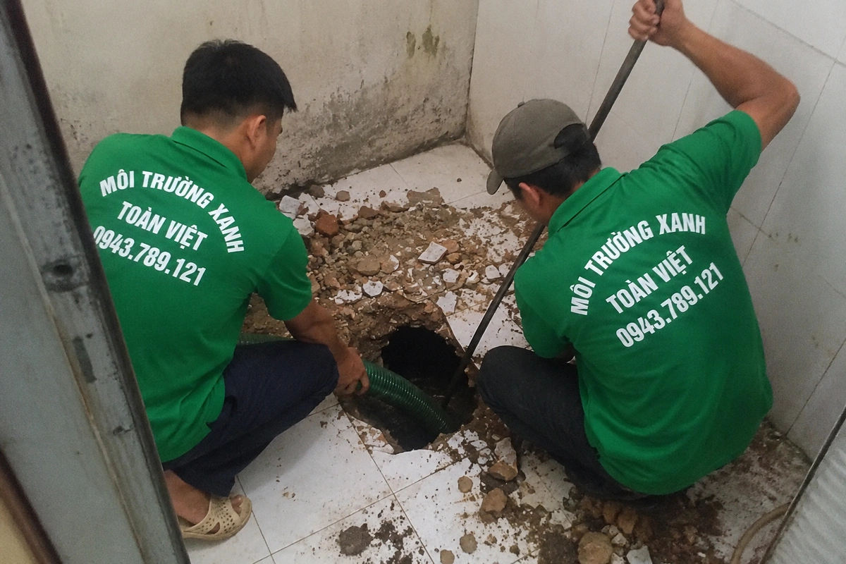 Nhân viên kiểm tra miệng hầm cầu trong lúc hút