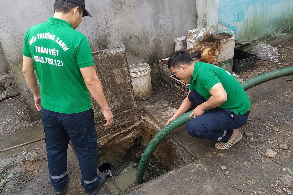 Nhân viên kiểm tra miệng hầm cầu trong lúc hút