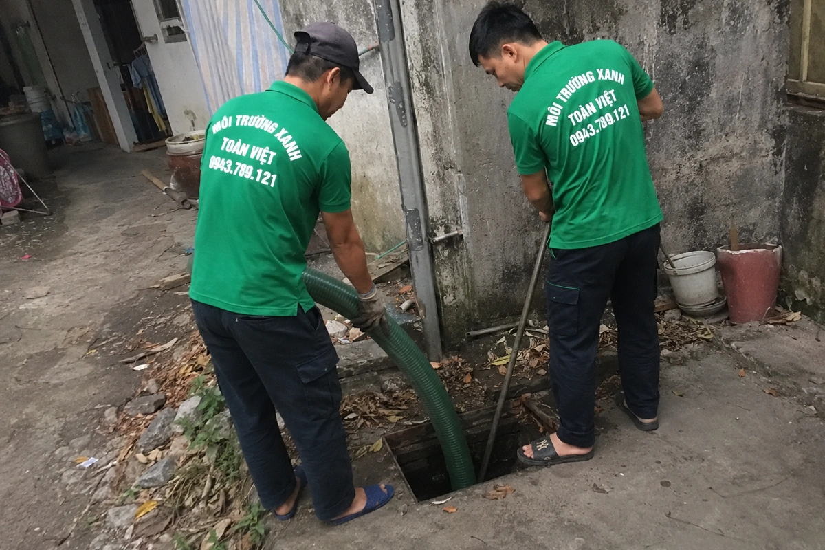 Nhân viên kiểm tra miệng hầm cầu trong lúc hút