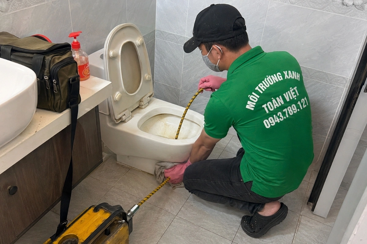 Kỹ thuật viên kiểm tra bồn cầu thoát nước chậm