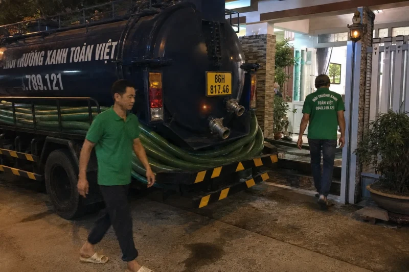 Nhân viên thu xếp tuyến ống bên xe bồn – hút hầm cầu Bình Thuận, Môi Trường Xanh Toàn Việt