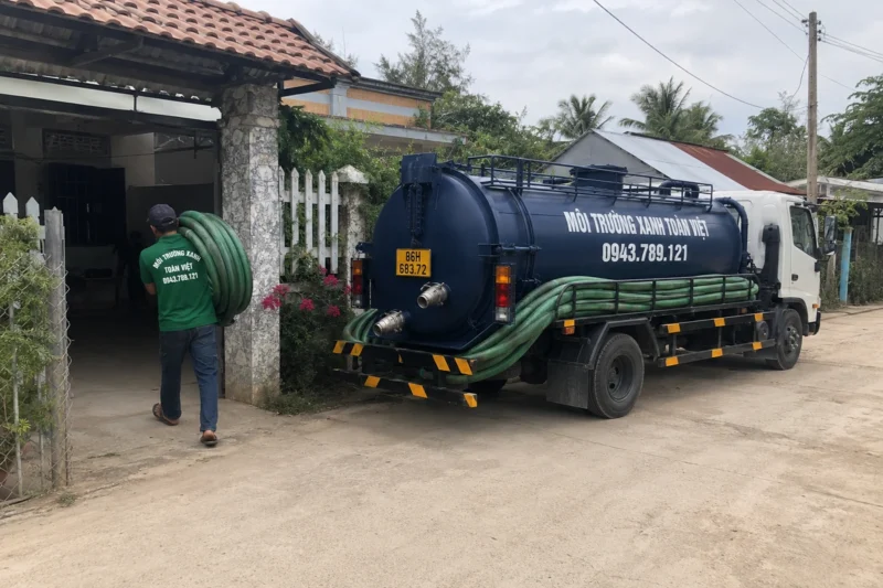 Xe bồn đỗ trước nhà và ống dẫn qua cổng – hút hầm cầu Bình Thuận, Môi Trường Xanh Toàn Việt
