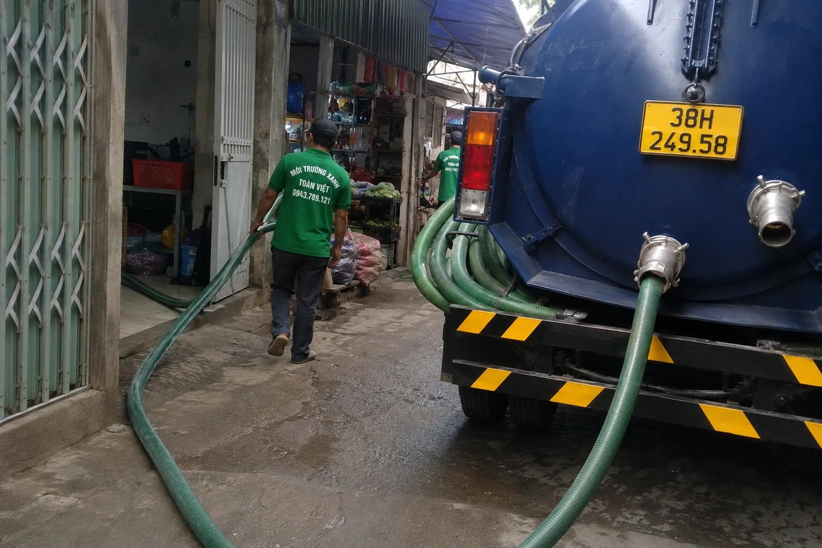 Hút Hầm Cầu Hà Tĩnh Khảo Sát Lối Ống Rồi Mới Báo Giá 11 Nhân viên kéo ống từ xe bồn vào nhà trong hẻm nhỏ tại Hà Tĩnh