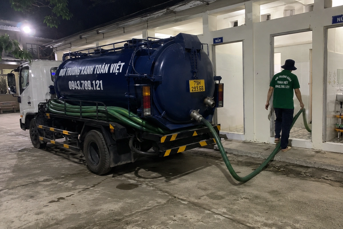 Nhân viên kéo ống từ xe hút hầm cầu vào nhà khách tại Khánh Hòa
