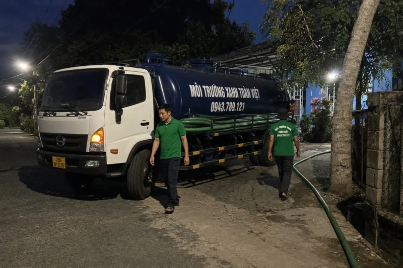 Xe hút với bồn chứa và ống trên đường dân cư