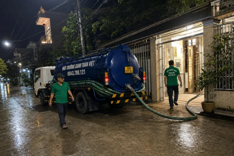 Hút hầm cầu Quảng Nam giá rẻ uy tín | Toàn Việt 49 Xe bồn và ống hút tại khu nhà vào buổi tối