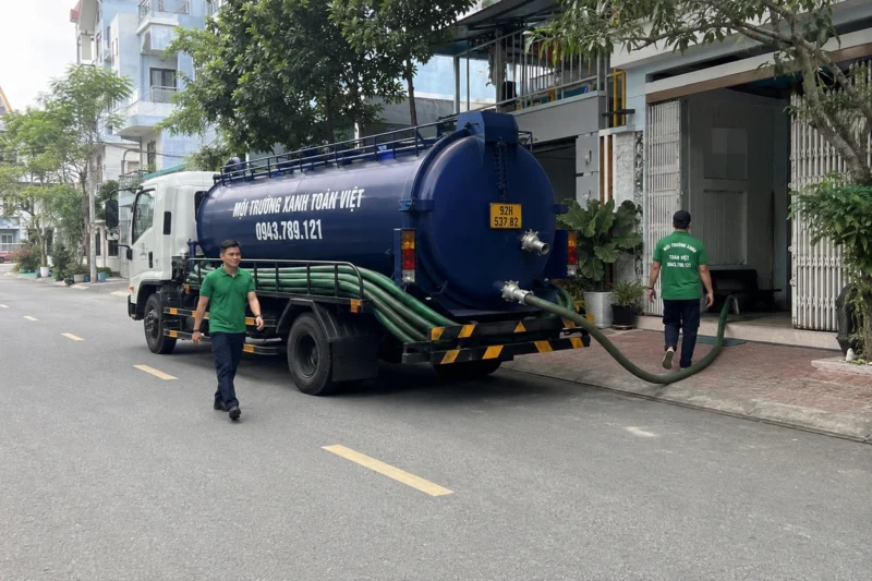 Hút hầm cầu Quảng Nam giá rẻ uy tín | Toàn Việt 34 Nhân viên di chuyển cạnh xe bồn đỗ ngoài đường