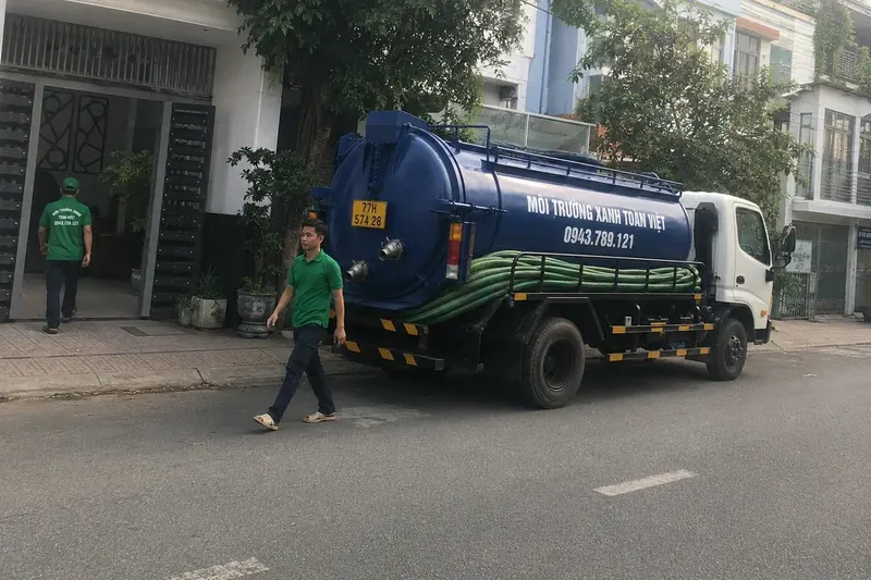 Hút hầm cầu Bình Định – Môi Trường Xanh Toàn Việt 41 Xe bồn và nhân viên tại điểm dừng bên đường
