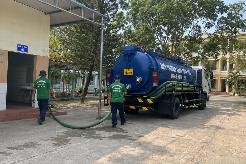 Hút hầm cầu Bình Định – Môi Trường Xanh Toàn Việt 45 Nhân viên và xe bồn ở khu vực sân rộng