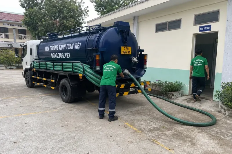 Hút hầm cầu Bình Định – Môi Trường Xanh Toàn Việt 47 Nhân viên đứng cạnh ống nối từ xe đến nhà