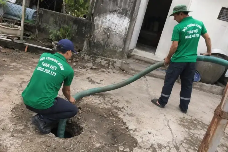 Hai nhân viên Toàn Việt đưa ống hút tới điểm mở trên nền sân