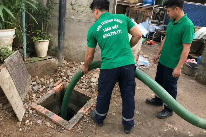 Nhân viên Toàn Việt bố trí ống tại một điểm mở bể ngoài nhà