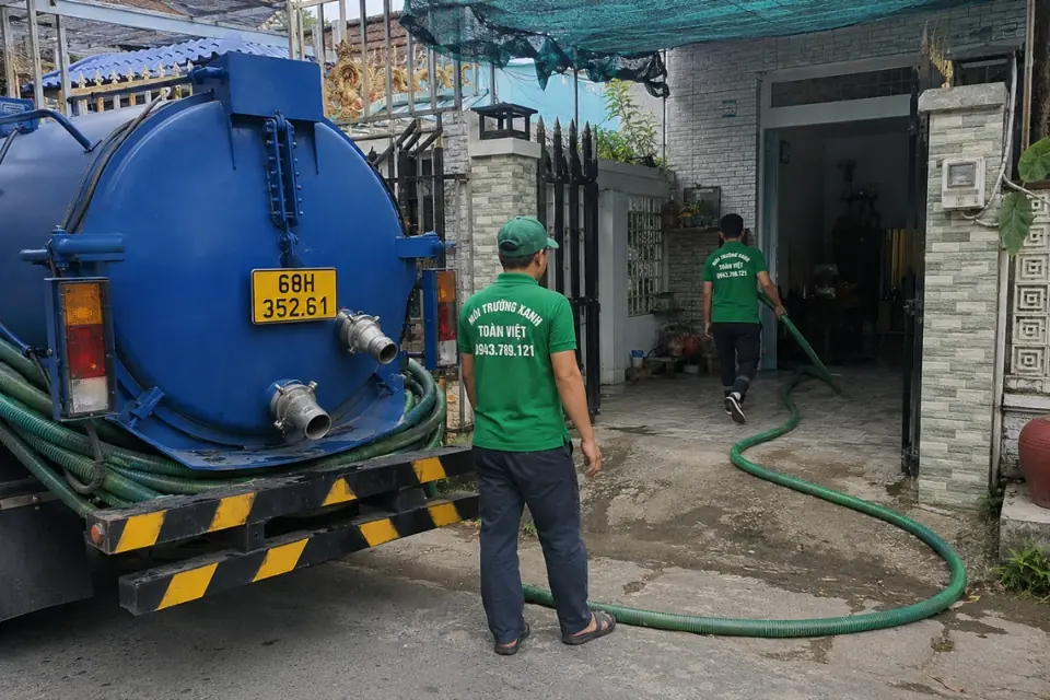 Nhân viên đứng cạnh đầu nối phía sau xe bồn