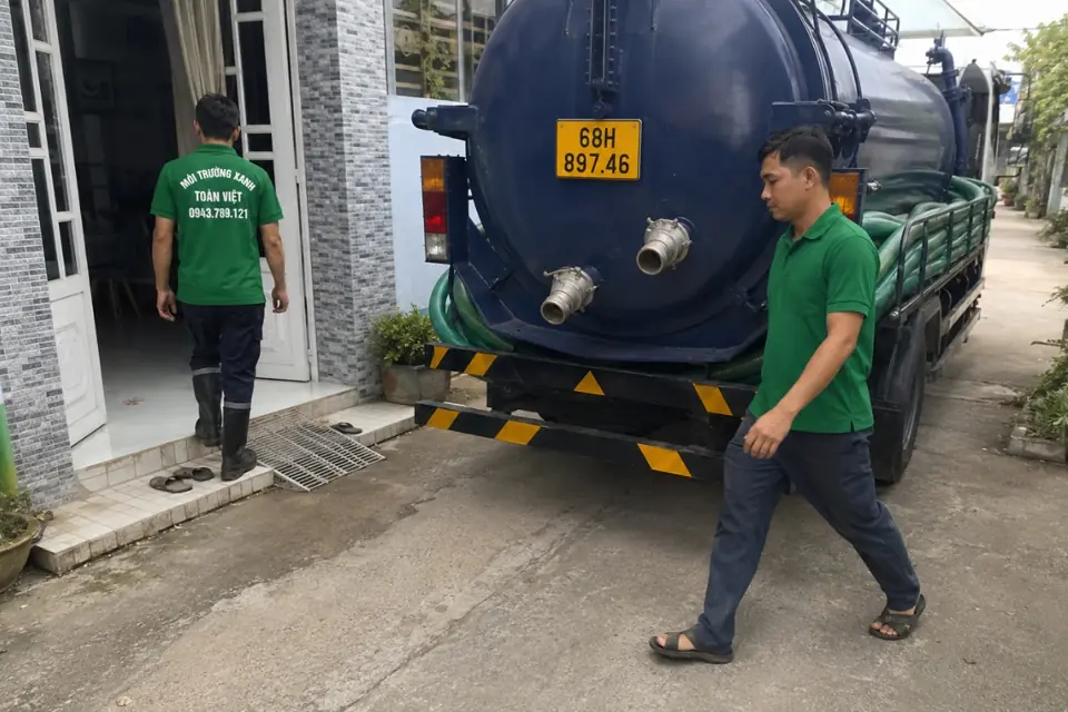 Hút hầm cầu An Minh giá rẻ uy tín | Toàn Việt 41 Nhân viên áo xanh và xe bồn tại lối vào khu nhà