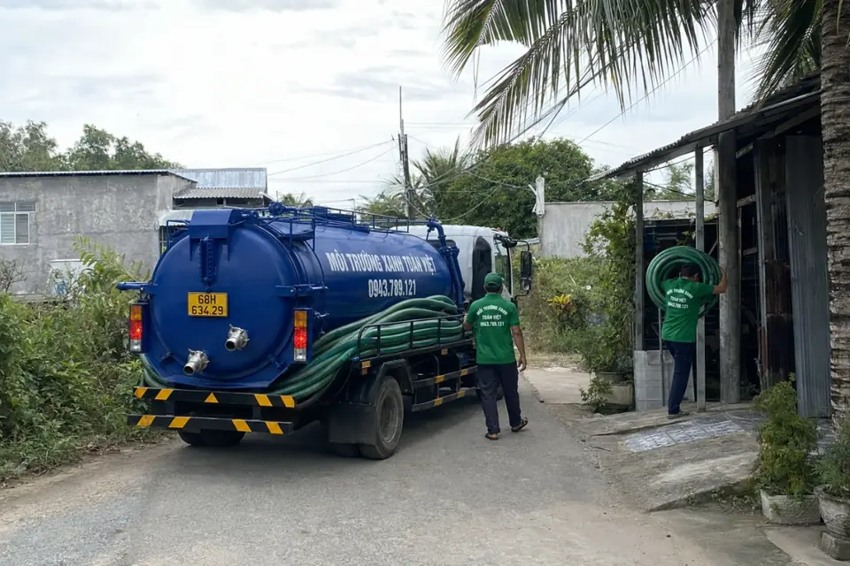 Xe bồn cùng nhân viên tại lối vào dưới hàng cây