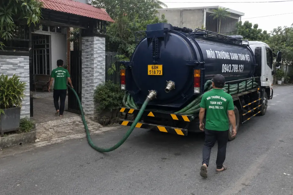 Nhân viên giữ ống cạnh đuôi xe bồn