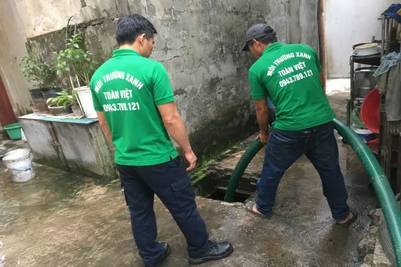 Hai thợ Toàn Việt bố trí đường ống hút ở sân