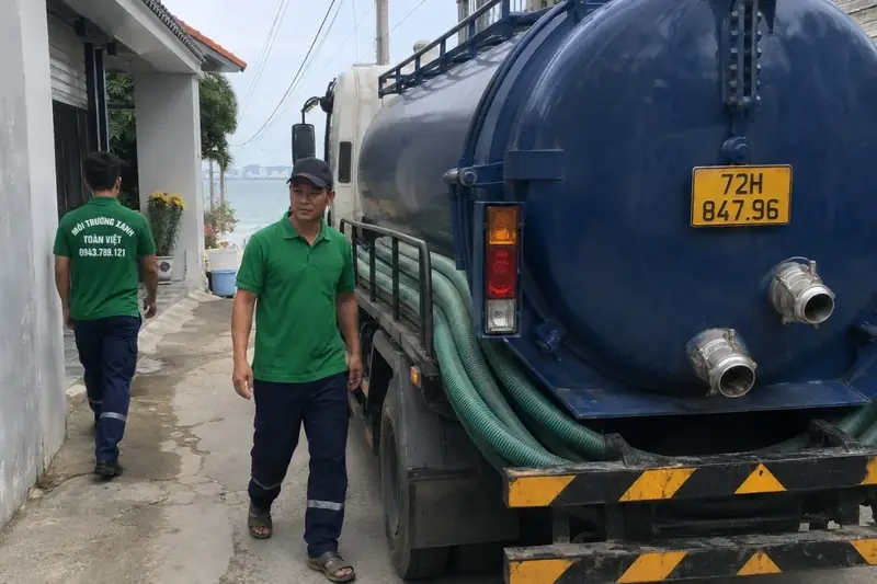 Xe bồn và nhân viên trong khoảng đường hẹp cạnh nhà