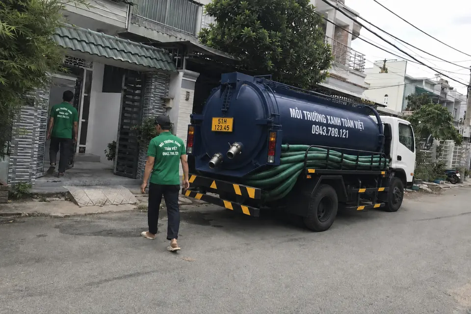Xe bồn và nhân viên trước lối vào nhà