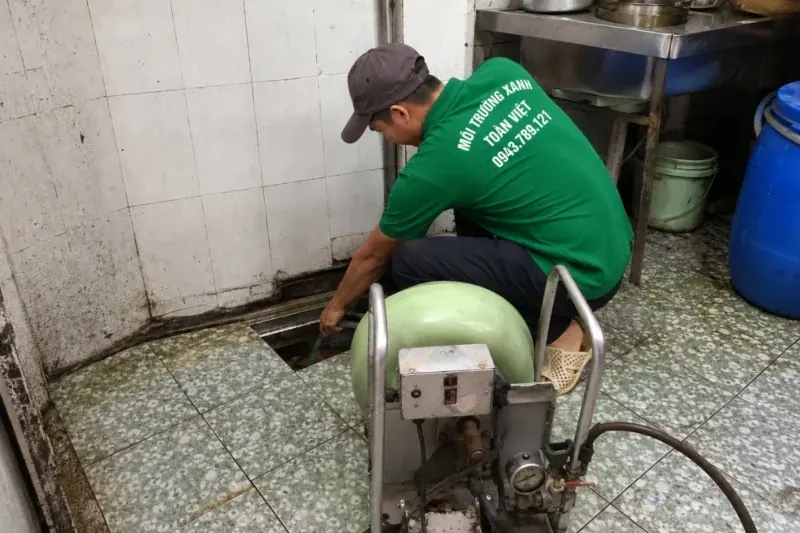 Nh&acirc;n vi&ecirc;n bố tr&iacute; m&aacute;y l&ograve; xo cạnh cửa thăm ở g&oacute;c bếp