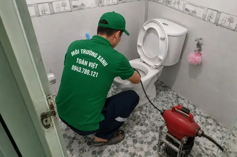 Thợ Toàn Việt kiểm tra bồn cầu cạnh máy thông màu đỏ